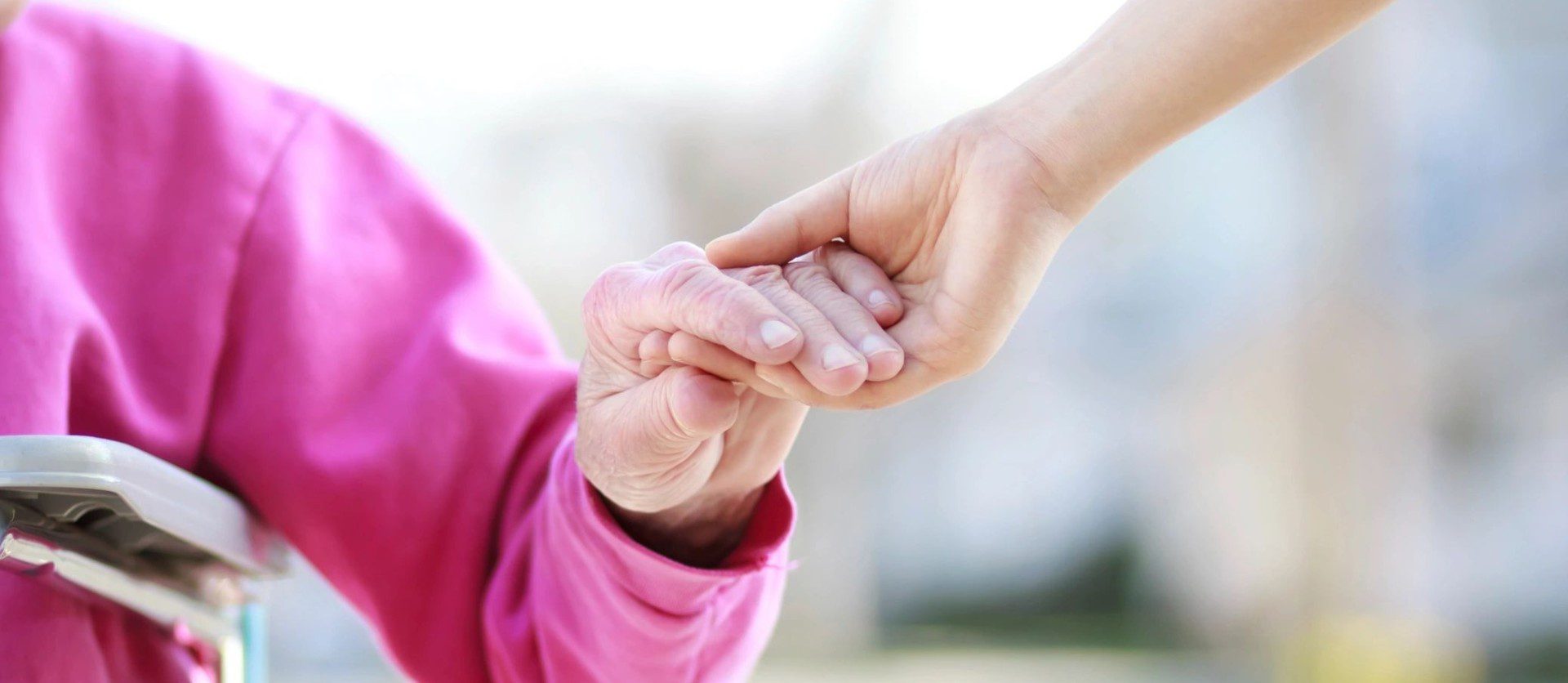 Senior lady in wheelchair holding hands