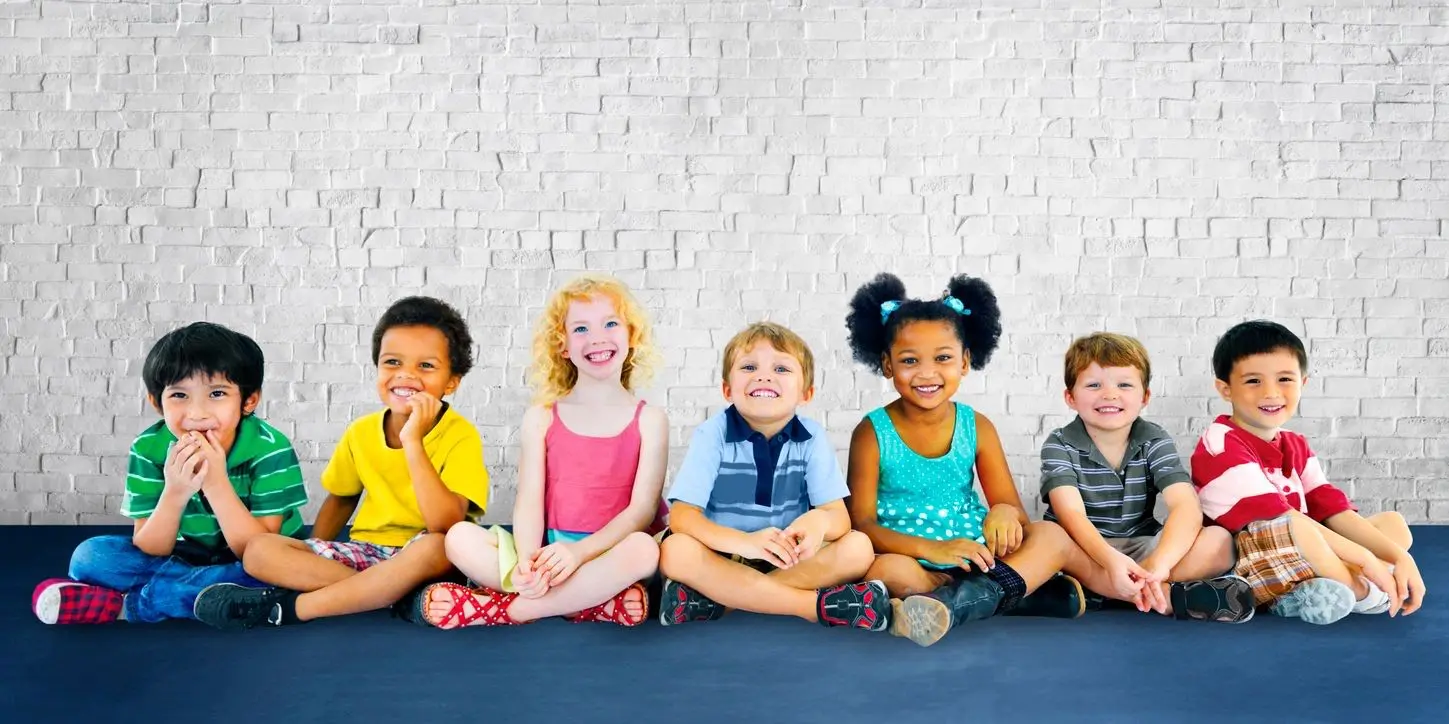 A group of children sitting on the ground.